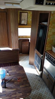 a kitchen area with a table, stove and oven in it's center room