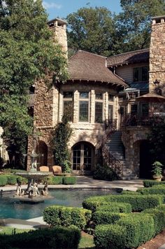 a large house with a fountain in front of it