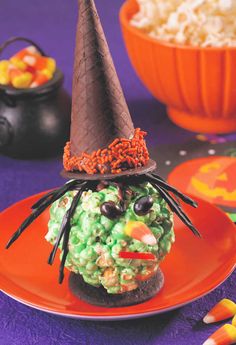 a plate topped with an ice cream covered in sprinkles and a halloween hat