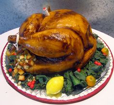 a roasted turkey on a platter with greens and lemons