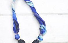 a blue and white necklace with black beads