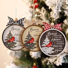 three ornaments hanging from a christmas tree decorated with red and white ribbon, some words written on them