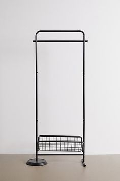 a metal rack with a wire basket on the bottom and two hooks attached to it