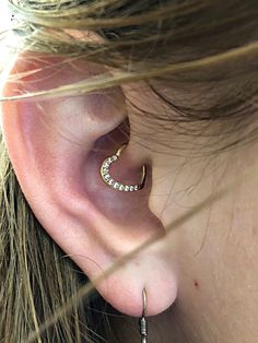 a close up of a person's ear with a small diamond hoop on it