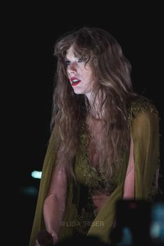 a woman with long hair standing in the dark