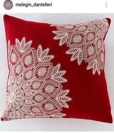 a red pillow with white lace on the front and back side, sitting against a white background