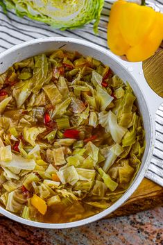 a white bowl filled with cabbage and red peppers