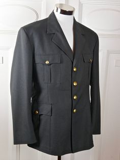 "This military jacket is in near mint condition and is a prime example of exquisite vintage Norwegian military tailoring. The European officer blazer is gunmetal gray, has a notch collar, and closes in the front with two gold buttons. The buttons have an upright crowned lion on them, as do the pockets on the four pockets on the front of the jacket (2 flap pockets at hip level and two on the chest). The NATO jacket has a center back vent that allow complete ease of movement. The jacket is fully l Military Style Formal Blazer With Buttons, Military Style Blazer With Buttons For Formal Occasions, Formal Military Blazer With Button Closure, Military Uniforms Long Sleeve Formal, Military Style Long Sleeve Formal Uniforms, Military Style Formal Outerwear With Pockets, Formal Military Uniform With Long Sleeves, Long Sleeve Military Formal Uniforms, Classic Formal Outerwear With Epaulettes