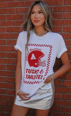 New and improved! One of our favorite designs "Tusks & Tailgates" got an upgrade this year and features a vintage Razorback helmet and trendy checkered frame. Pair with a cute skirt or denim cut offs for an easy gameday look. WE ONLY OFFER STORE CREDIT FOR RETURNS! Feel free to email us at orders@shopriffraff.com or DM us with any questions regarding fit, styling, or our return policy in general. Arkansas Razorbacks Crafts, Razorback Shirt, Arkansas Razorback, Cut Offs, Arkansas Razorbacks, Cute Skirt, Denim Cutoffs, New And Improved, Cute Skirts