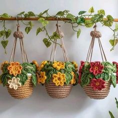 three hanging baskets filled with flowers on top of a wall