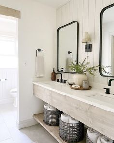 a white bathroom with two sinks and mirrors