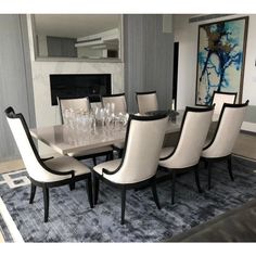 a dining room table with white chairs around it