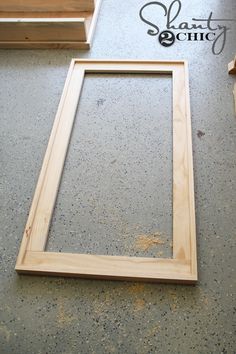 a wooden frame sitting on top of a floor next to some wood planks and plywood