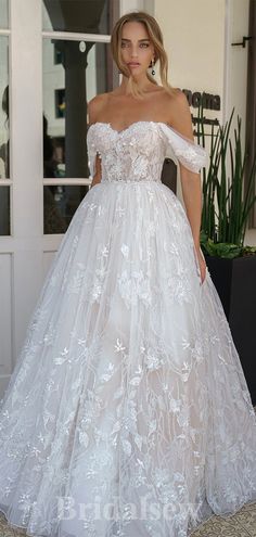 a woman in a white wedding dress standing outside