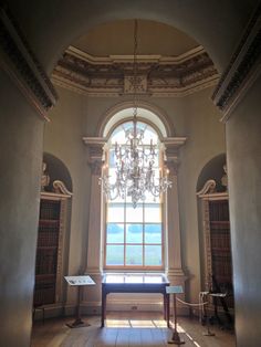 an empty room with a chandelier hanging from it's ceiling and windows