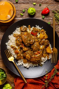 a black plate topped with rice and meat