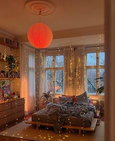 a bed room with a neatly made bed and lots of lights on the windowsill