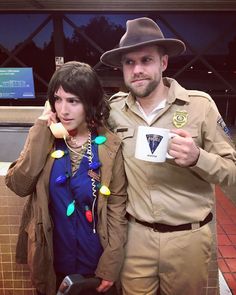 a man and woman dressed up in costumes posing for a photo while holding coffee cups