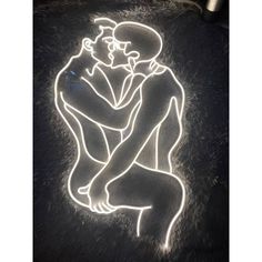 a neon sign with two people hugging each other