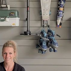 a woman standing in front of a wall with skateboards and shoes hanging on it