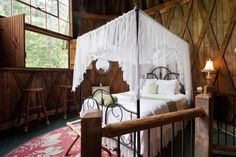 a canopy bed in a rustic cabin bedroom