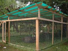 a chicken coop with a green roof in the grass