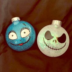 two blue and white ornaments with faces painted on them