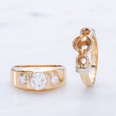 two gold rings with diamonds on them