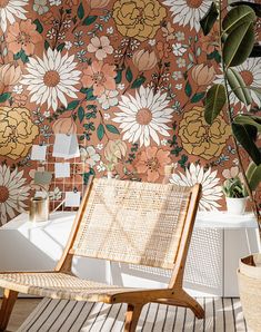 a chair sitting on top of a wooden floor next to a wall covered in flowers