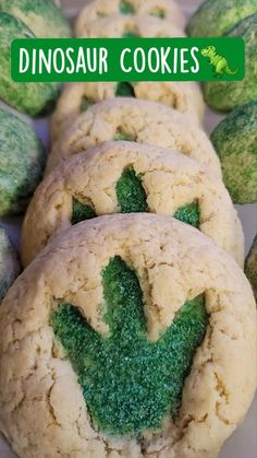 some cookies with green leaves on them and the words dinosaur cookies written in white letters