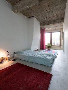 a bedroom with a red rug on the floor