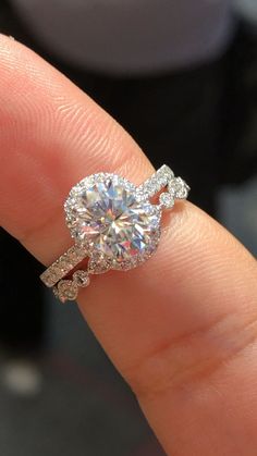 a close up of a person's hand holding a diamond ring