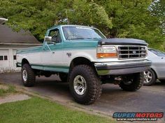 a green and white truck parked in front of a house