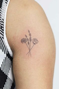 a woman's arm with a small tattoo on the back of her left shoulder