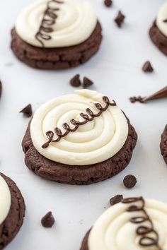 chocolate cookies decorated with white frosting and chocolate chips