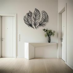 a white room with a vase and two black feathers on it's wall above a table