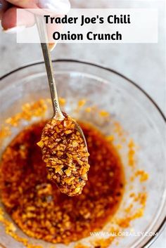 a person holding a spoon full of food in a bowl with the words trader joe's chili onion crunch