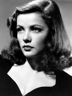 an old black and white photo of a woman with long hair wearing a dress in the 1950's