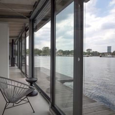 a white chair sitting on top of a wooden floor next to a large glass window