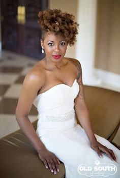 a woman in a white dress sitting on a couch