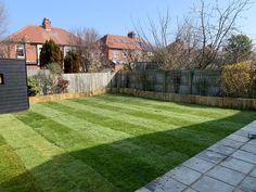 an empty backyard with grass and brick pavers