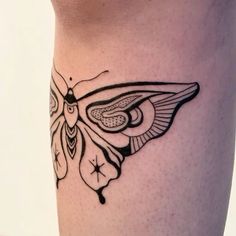 a black and white butterfly tattoo on the leg