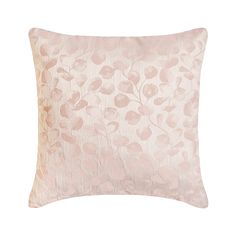 a pink pillow on a white background with an embroidered flower design in the center and bottom