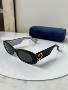 Brand new Gucci GG0517S 001 Black Sunglasses. Rounded oval sunglasses with gold logos on temples. Metallic silver inside the frame for a subtle pop! Super lightweight and perfect for every day wear. Comes with case, matching satin pouch, cloth, and all paperwork. Size 52-20-145. 100% authentic and unworn. No defects. Retail price $435. Made in Italy. Gucci Luxury Tinted Sunglasses, Chic Gucci Luxury Shield Sunglasses, Black Oval Sunglasses, Satin Pouch, Brand Clothes, Men's Eyeglasses, Gucci Sunglasses, Gold Logo