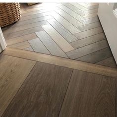 a wood floor with herringbones in the middle and a basket next to it