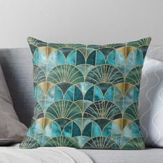 a blue and gold art deco pillow on a couch