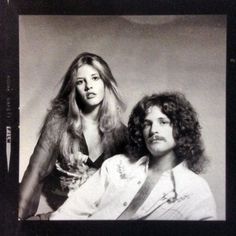 an old photo of two women sitting next to each other, one with long hair