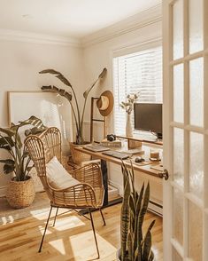 a room with a desk, chair and potted plants