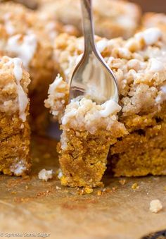 a close up of a fork in a piece of cake with crumbs on it