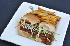 a white plate topped with two sandwiches and french fries